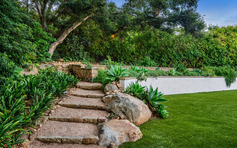 Narrow path with big rocks between lawns